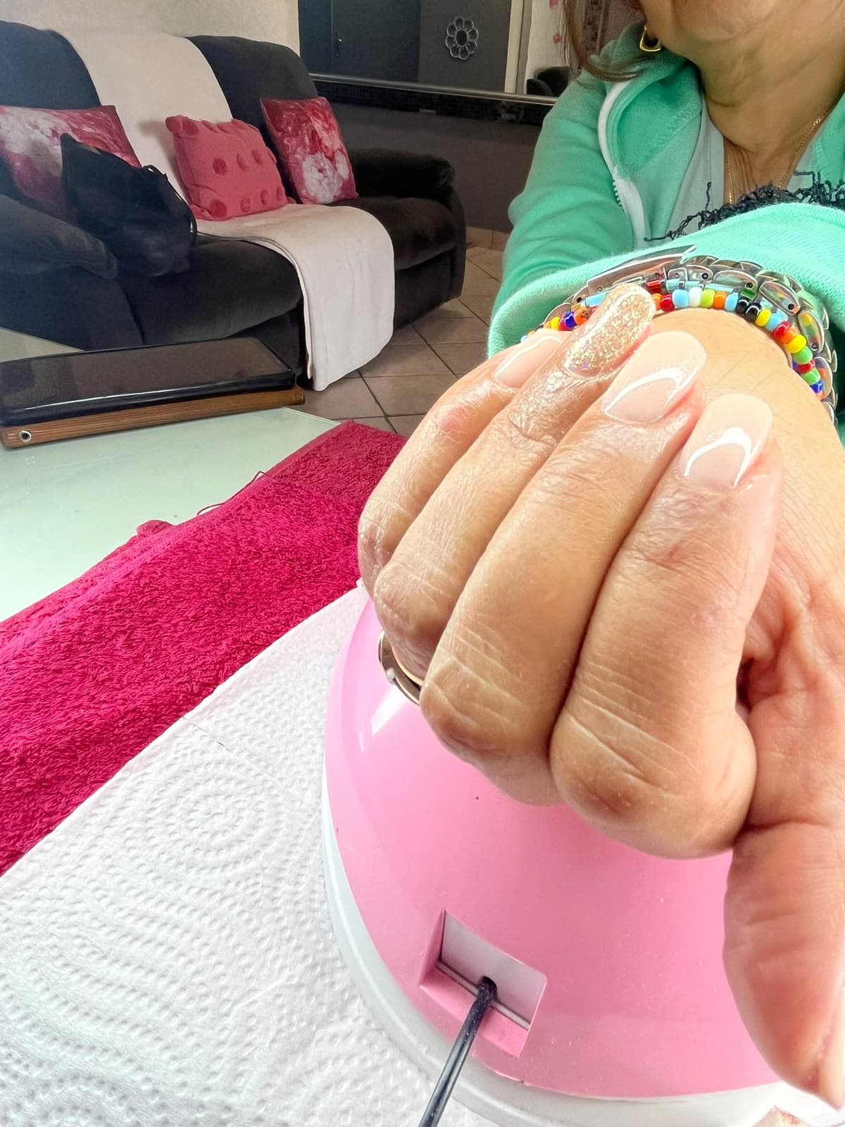 Side view of a nude gel manicure with a glitter accent nail